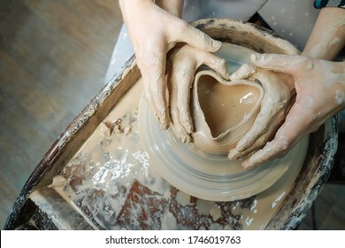 Couple hands making a pot in the shape of a heart. Date at the pottery workshop. Concept of love - Powered by Shutterstock