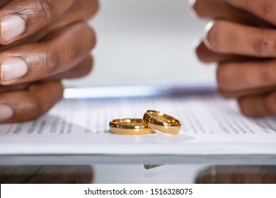 Couple Hands On Divorce Agreement Near Wedding Rings