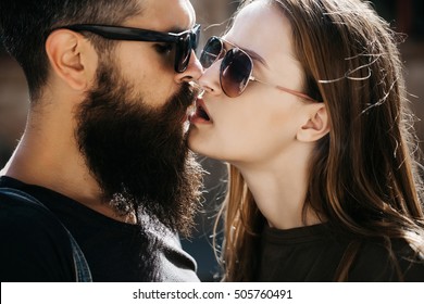 Couple Of Handsome Bearded Strong Man With Black Glasses And Long Beard And Pretty Sexy Cute Woman Smoking Outdoor, Close Up