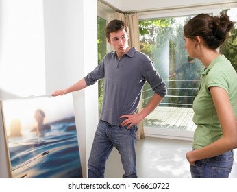 Couple Hanging A Painting