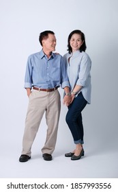 A Couple Of Happiness Asian Old Man And Old Woman Standing In Studio White Background. Isolated Picture Of Smiling Asian Elderly Man And Woman In Studio.