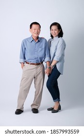 A Couple Of Happiness Asian Old Man And Old Woman Standing In Studio White Background. Isolated Picture Of Smiling Asian Elderly Man And Woman In Studio.