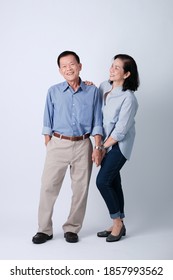 A couple of happiness asian old man and old woman standing in studio white background. Isolated picture of smiling asian elderly man and woman in studio.