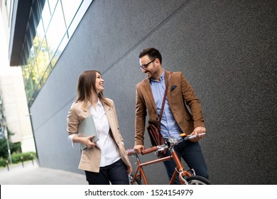 Couple Of Happy Colleagues Talking While Walking In The Street