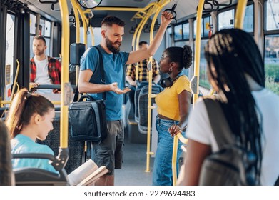 Couple of happy multiracial friends having fun while commuting together by a bus. Happy diverse friends talking while driving in the city bus. Friendship, public transport and people concept. - Powered by Shutterstock