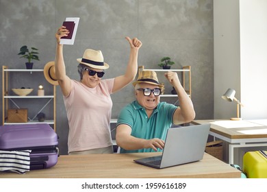 Couple Of Happy Senior Travelers Find Good Cheap Accommodation For Summer Holiday. Excited Old Husband And Wife Getting Ready For Vacation Trip, Shopping Online And Browsing Hot Sale Website On Laptop