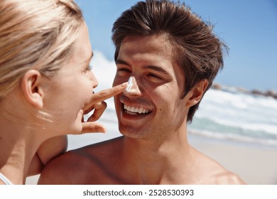 Couple, happy and sunscreen at beach for bonding, travel and tropical holiday with sunshine on sand. Man, woman and playful outdoor for trip, love and vacation with summer, relax and hug in Santorini - Powered by Shutterstock