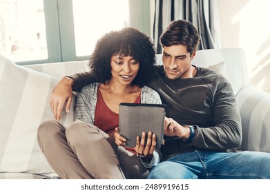 Couple, happy and tablet with streaming, watching movie and bonding in lounge, sofa and home on break. Woman, man and technology as interracial partner in together, cheerful and embrace in connection - Powered by Shutterstock