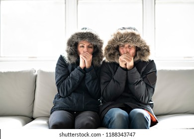 Couple Have Cold On The Sofa At Home With Winter Coat