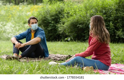 Couple Have Date During The Coronavirus Lockdown Crisis. Man And Woman In The Park. Social Distancing And Virus Protection.