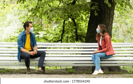 Couple have date during the coronavirus lockdown crisis. Man and woman in the park. Social distancing and virus protection.