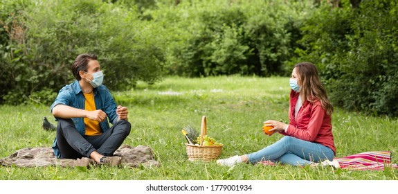 Couple Have Date During The Coronavirus Lockdown Crisis. Man And Woman In The Park. Social Distancing And Virus Protection.