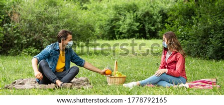 Couple have date during the coronavirus lockdown crisis. Man and woman in the park. Social distancing and virus protection.