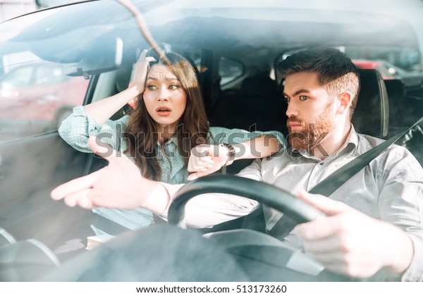 Couple have\
a dispute in car. woman holding her\
head