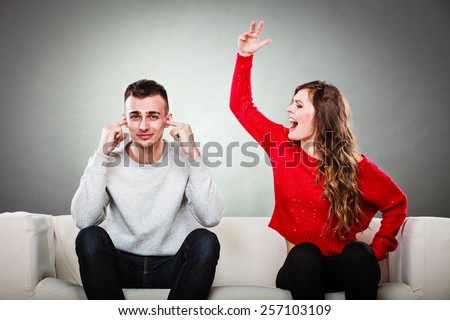 couple having argument - conflict, bad relationships. Angry fury woman screaming man closes his ears.