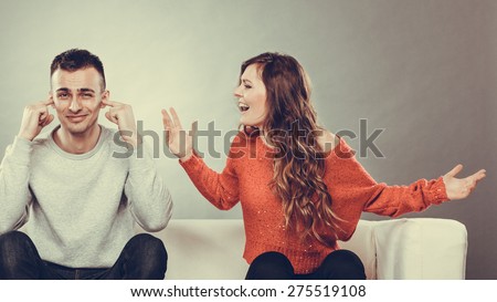 couple having argument - conflict, bad relationships. Angry fury woman screaming man closing his ears.
