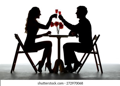 Couple Having Dinner With Wine Glass On Table. silhouettes on white background