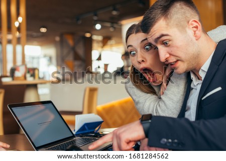 Couple having fun in a cafe ( coffee shop) while making crazy faces and fooling around