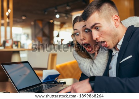 Couple having fun in a cafe ( coffee shop) while making crazy faces and fooling around
