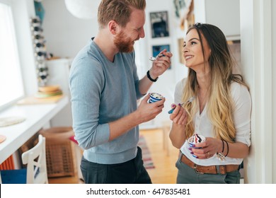 Couple Having Fun And Laughing At Home While Eating Ice Cream