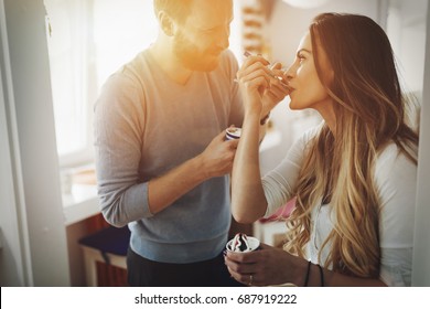 Couple Having Fun And Laughing At Home While Eating Ice Cream