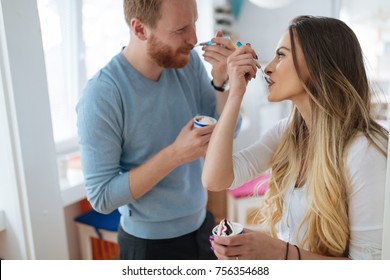 Couple Having Fun And Laughing At Home While Eating Ice Cream