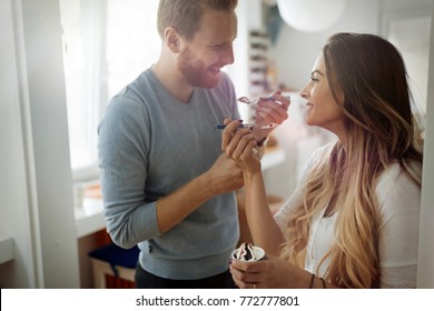 Couple Having Fun And Laughing At Home While Eating Ice Cream