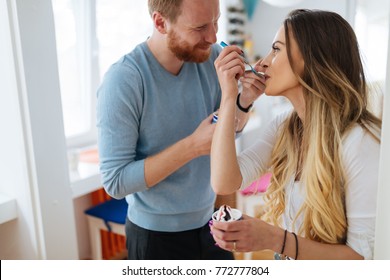 Couple Having Fun And Laughing At Home While Eating Ice Cream