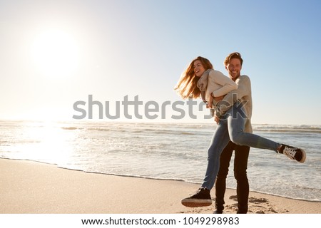 Couple Having Fun On Winter Beach Together
