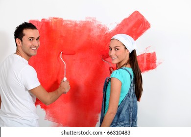 Couple Having Fun Painting Their New House