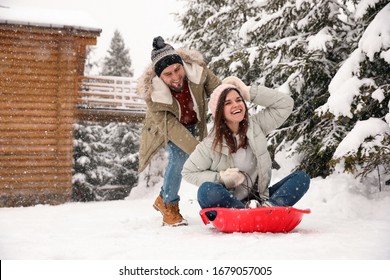 Couple Having Fun And Sledding On Snow. Winter Vacation