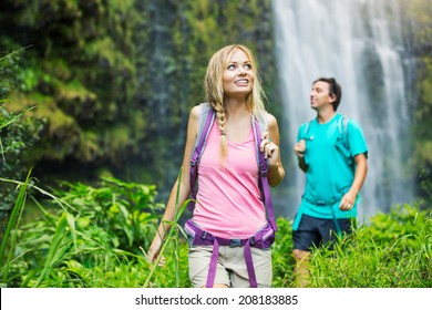 Couple Having Fun Together Outdoors On Hike To Amazing Waterfall In Hawaii.