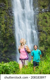 Couple Having Fun Together Outdoors On Hike To Amazing Waterfall In Hawaii.