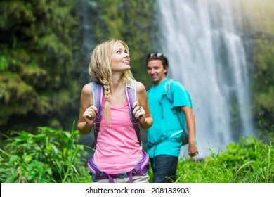 Couple Having Fun Together Outdoors On Hike To Amazing Waterfall In Hawaii.