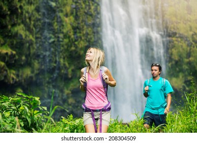 Couple Having Fun Together Outdoors On Hike To Amazing Waterfall In Hawaii.