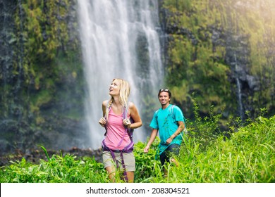 Couple Having Fun Together Outdoors On Hike To Amazing Waterfall In Hawaii.