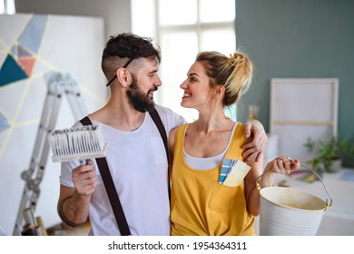 Couple Having Fun When Painting Wall Indoors At Home, Relocation And Diy Concept.