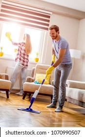 Couple Having Fun While Doing Spring Cleaning Together