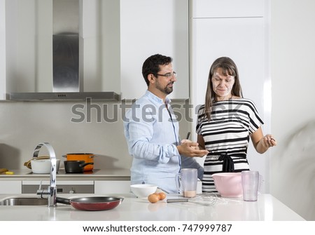 couple having fun while preparing food in a kitchen