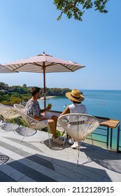 Couple Having Lunch At A Restaurant Looking Out Over The Ocean Of Pattaya Thailand, Man And Woman Having Dinner In A Restaurant By The Ocean In Pattaya. 