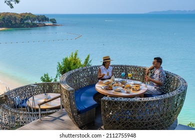 couple having lunch at a restaurant looking out over the ocean of Pattaya Thailand, man and woman having dinner in a restaurant by the ocean in Pattaya.  - Shutterstock ID 2112755948