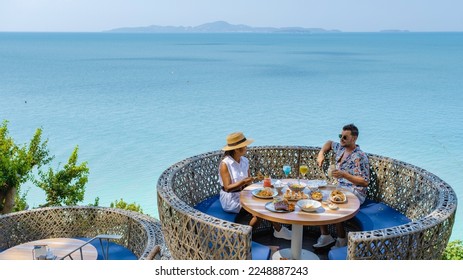 couple having lunch at a restaurant looking out over the ocean of Pattaya Thailand, man and woman having dinner in a restaurant by the ocean in Pattaya. - Powered by Shutterstock