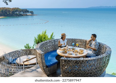 couple having lunch at a restaurant looking out over the ocean of Pattaya Thailand, man and woman having dinner in a restaurant by the ocean in Pattaya. - Powered by Shutterstock