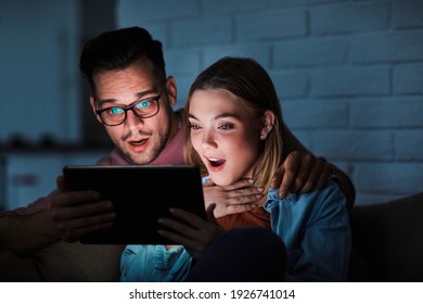 Couple having movie night at home watching a tablet computer - Powered by Shutterstock