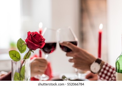 Couple Having A Romantic Dinner And Toasting With Cups Of Red Wine.