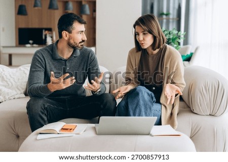 Couple having a serious conversation while looking at online documents for budgeting