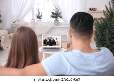 Couple having video chat with man via laptop at home