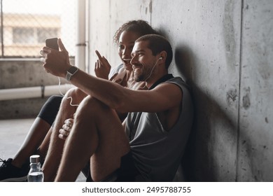 Couple, health and exercise break with phone for fitness podcast, streaming in building for wellness. Man, woman or mobile app for workout together with rest in parking lot, music for gym or training - Powered by Shutterstock