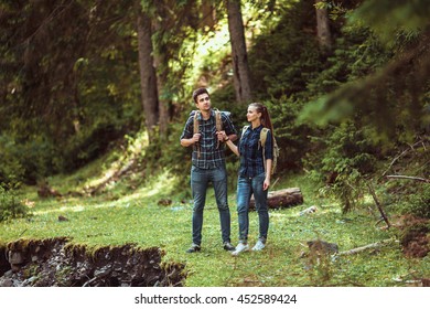 A couple hikers Hiking with backpacks walk along a beautiful mountain area. The concept of active rest