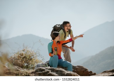 Couple Hikers Taking A Break On The Mountaintop